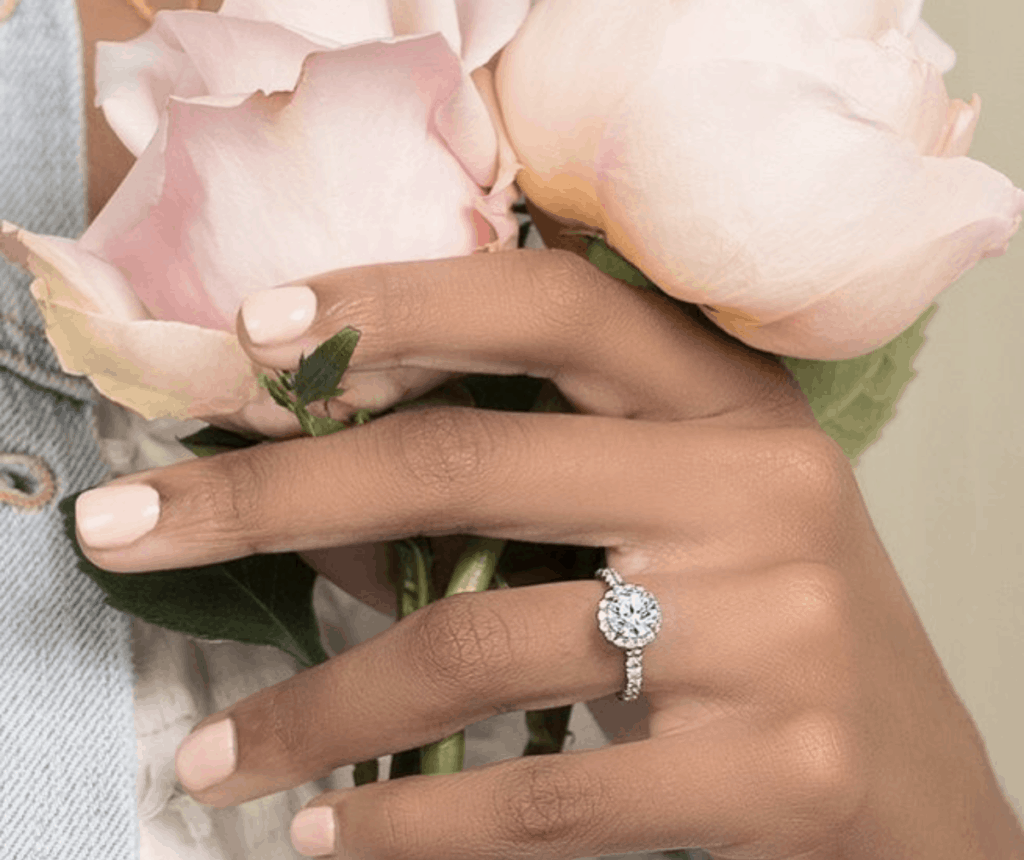 Round Engagement Ring On Hand With Flowers